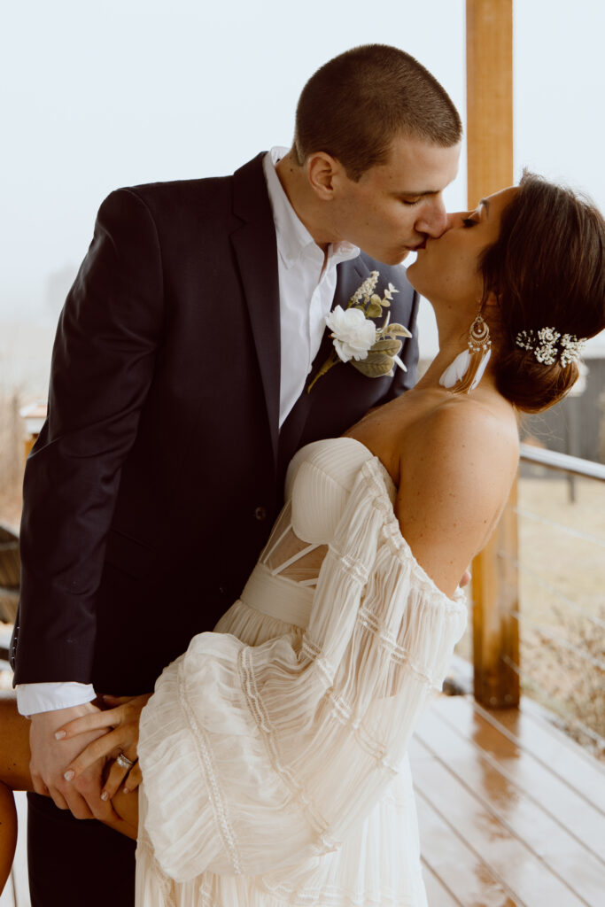 A couple kissing after their elopement ceremony in Pennsylvania. The bride is leaning back as he groom holds her.