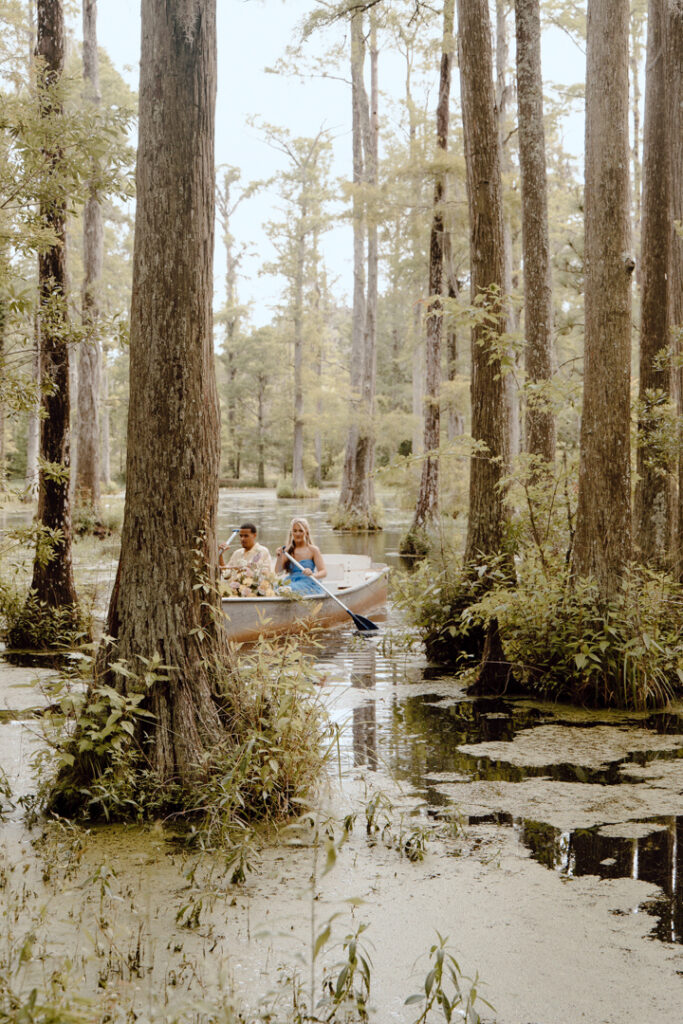 A couple canoeing on their wedding day, in a forested elopement location.