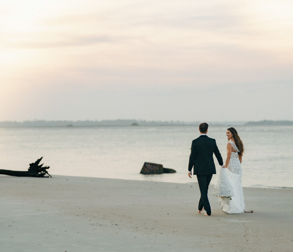 One of the best things to do when you elope is to choose a location you love - like this couple walking on the beach.